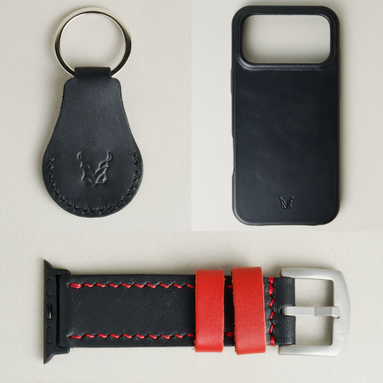 Three premium leather items for apple products: midnight black airtag keychain with metal key ring and embossed Markore logo, midnight black iphone 17 case with embossed Markore logo and midnight black and red watch strap with silver stainless steel buckle and black adapter.