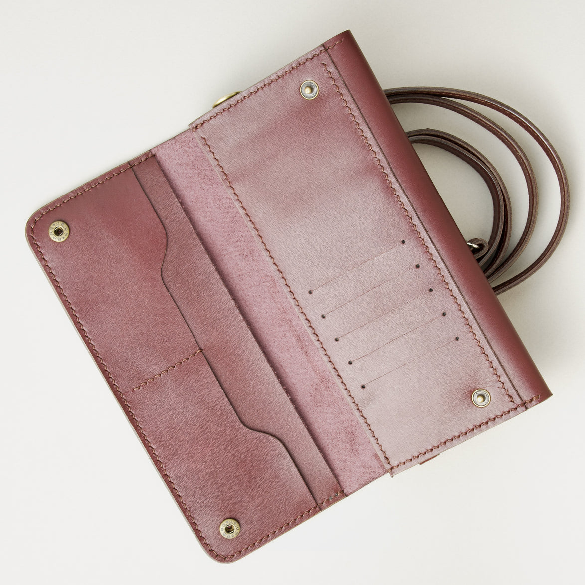Inside view of horizontal full-grain leather crossbody bag in Espresso Brown, showing card slots, handmade stitching and brass press studs. Markore Gul Sahar.