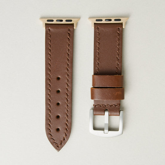 Espresso brown full-grain leather watch strap with rose gold stainless steel adapters and silver buckle, featuring handmade stitching and matching loops. Markore Hour Line.