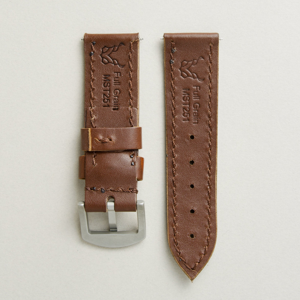 Back view of espresso brown leather strap with stainless steel buckle, showing handmade stitching, embossed logo, and serial number. Markore Hour Line.
