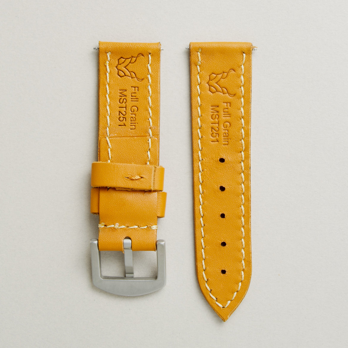 Back view of amber leather strap with stainless steel buckle, showing handmade stitching, embossed logo, and serial number. Markore Hour Line.