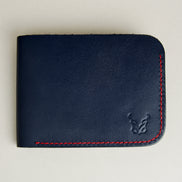 Front view of full-grain leather bifold wallet with hand-stitched red thread in Dark Blue and embossed logo. Markore Hunza Arc.