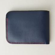 Back view of full-grain leather bifold wallet with hand-stitched red thread in Dark Blue and embossed logo. Markore Hunza Arc.