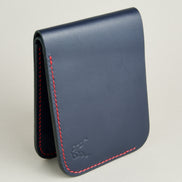 Side view of full-grain leather bifold wallet with hand-stitched red thread in Dark Blue and embossed logo. Markore Hunza Arc.