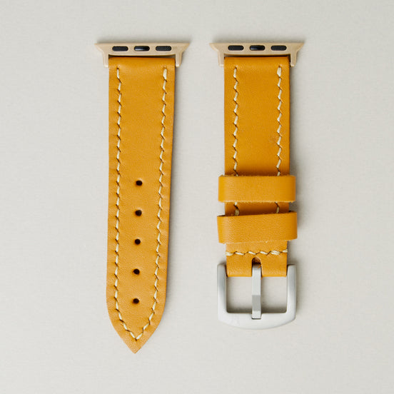 Amber full-grain leather watch strap with rose gold stainless steel adapters and silver buckle, featuring handmade stitching and matching loops. Markore Hour Line.