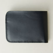 Back view of full grain leather bifold wallet in midnight black featuring handmade stitching. Markore Hunza Fold.