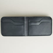 Inside view of full grain leather bifold wallet in midnight black featuring handmade stitching and card slots. Markore Hunza Fold.