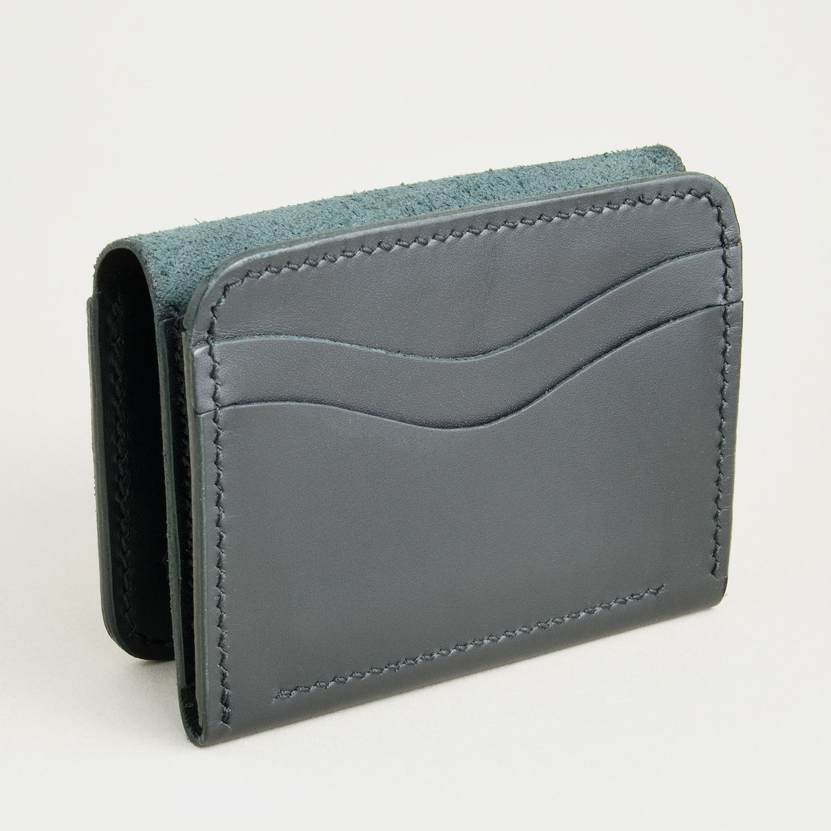 Opened side view of midnight black full-grain leather flap fold wallet featuring a flap closure, card slots and handmade stitching. Markore Khaas Andaz.