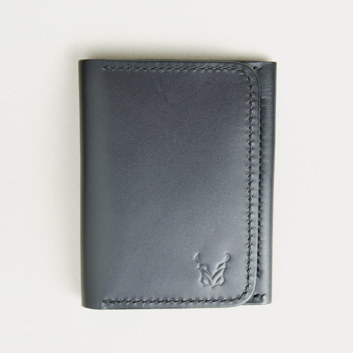 Front view of midnight black full-grain leather flap fold wallet featuring a flap closure, handmade stitching and embossed logo. Markore Khaas Andaz.