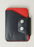 Front view of full grain leather card holder in black and red, featuring side flap with two stainless steel press buttons, red handmade stitching and embossed logo. Markore Niva Glide.