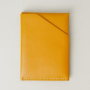 Back view of full grain leather card holder in amber with ivory handmade stitching and card slot. Markore Niva Heritage.