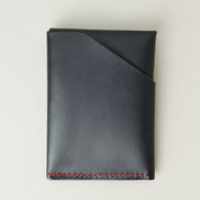 Back view of full grain leather card holder in black with red handmade stitching and card pocket. Markore Niva Heritage.