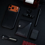 markore niva heritage in midnight black with red stitching and markore shell frame iphone 17 pro leather case sitting on a black surface
