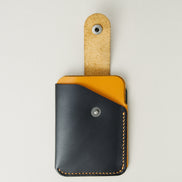 Front view of full grain leather card holder with open loop in midnight black and amber, featuring a leather loop with stainless steel press button and handmade stitching. Markore Niva Loop.
