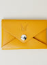 Front view of full grain leather envelope style wallet in amber with stainless steal press button and embossed logo. Markore Niva Seal.