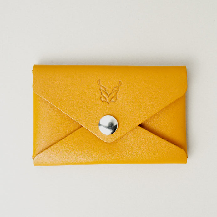 Front view of full grain leather envelope style wallet in amber with stainless steal press button and embossed logo. Markore Niva Seal.