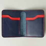 Inside view of dark blue full-grain leather wallet featuring red and blue card slots and red handmade stitching. Markore Ravi Fold.