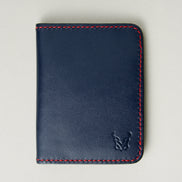 Front view of dark blue full-grain leather wallet featuring red handmade stitching and embossed logo. Markore Ravi Fold.