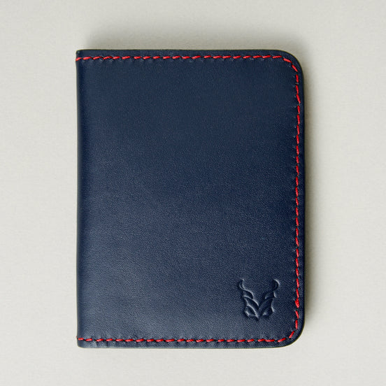 Front view of dark blue full-grain leather wallet featuring red handmade stitching and embossed logo. Markore Ravi Fold.