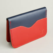 Side view of dark blue full-grain leather wallet featuring red card slot, red handmade stitching and embossed logo. Markore Ravi Slip.