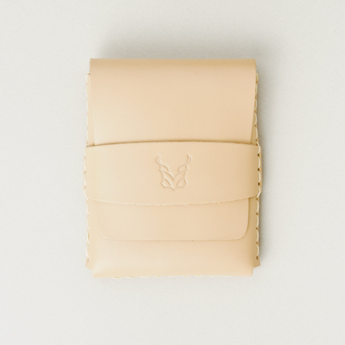 Front view of natural full-grain leather flap wallet featuring a flap holder with embossed logo, and handmade stitching. Markore Sutlej Vault.