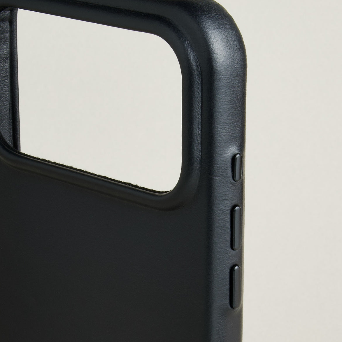 Detail of midnight black leather iphone 17 pro case with full cutout and buttons. Markore Shell Frame.