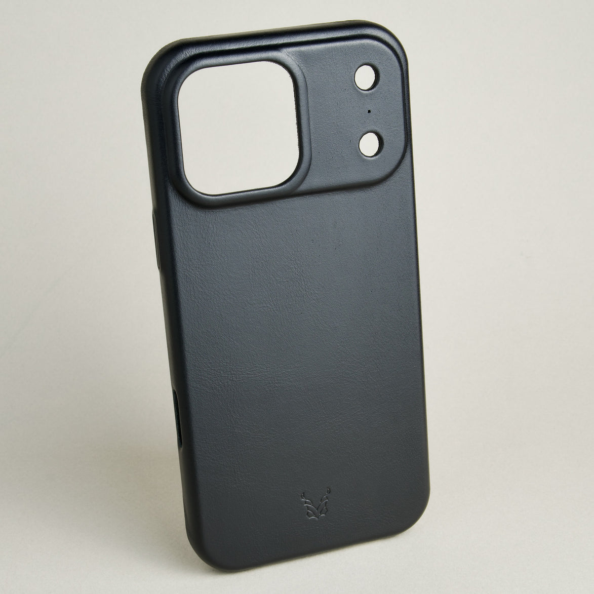 Outside side view of midnight black leather iPhone 17 pro cover wiht camera cutout featuring embossed brand logo. Markore Shell Guard.