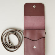 Inside view of vertical full-grain leather crossbody bag and matching shoulder strap in Espresso Brown, showing handmade stitching and stainless steel press stud. Markore Nora Veldt.