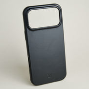Outside side view of midnight black leather iPhone 17 cover showing embossed brand logo. Markore Shell Guard.
