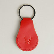 Back view of red AirTag keychain in full-grain leather with round metal key ring and embossed logo. Markore Tag Mate.