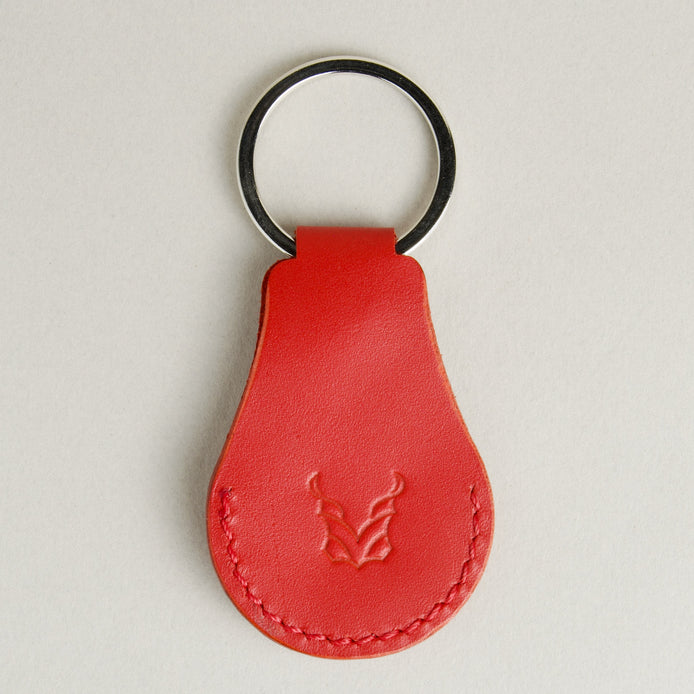 Back view of red AirTag keychain in full-grain leather with round metal key ring and embossed logo. Markore Tag Mate.